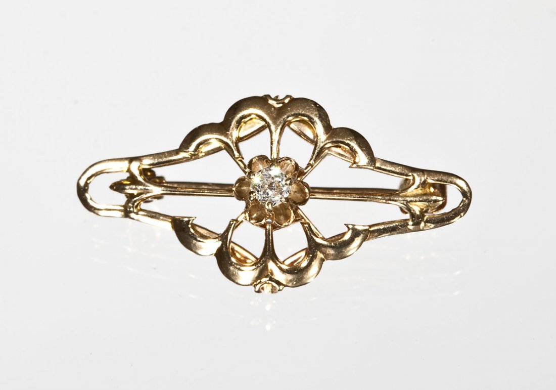 .05 Ct Diamond & 10K Gold Brooch: DESCRIPTION: 10K yellow gold open design brooch set with one .05 carat Old European cut diamond. 1" x 1/2". .8 dwt (1.3 gr).
