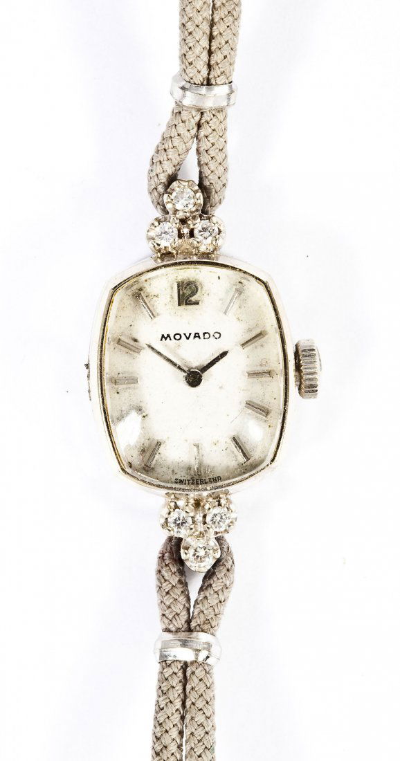 Lady's Movado 14K Gold & Diamond Wristwatch: DESCRIPTION: Lady's Movado wristwatch. White dial with silver numeral markers, marked "Movado Switzerland". Movement marked "Movado Factories 17 Seventeen Jewels Adj. 2 Two Pos. Swiss". In a marked Mo