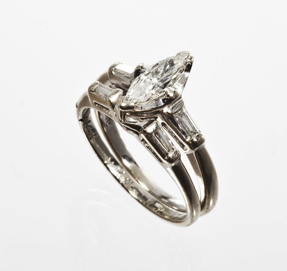 .60 CTW Diamond Wedding Set: DESCRIPTION: Diamond wedding set in marked 14K white gold. Set with one .44 carat marquise cut diamond and two approximately .04 carat baguette side diamonds. Wedding band set with two approximately .