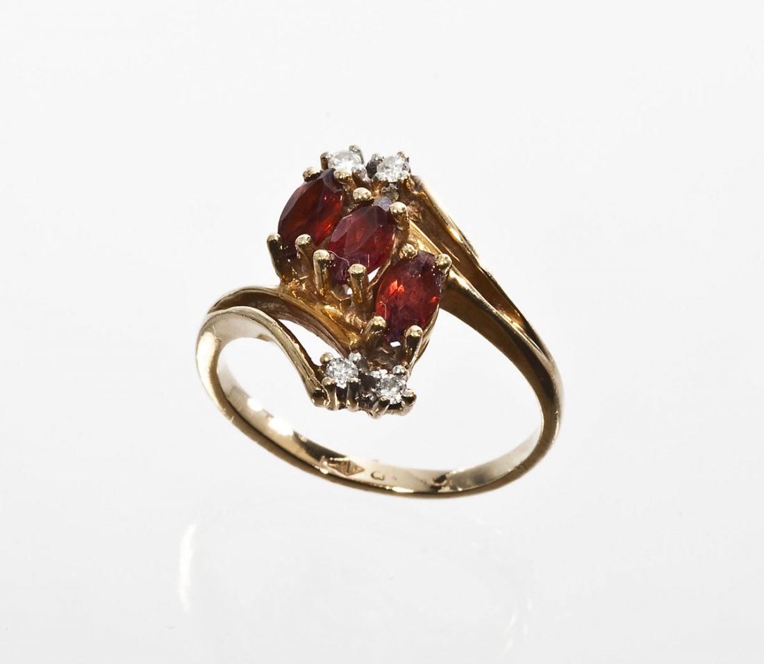 14K Diamond & Garnet Ring: DESCRIPTION: Diamond and garnet ring in marked 14K yellow gold. Set with three approximately 6mm x 3mm marquise cut garnets and four approximately 2-1/2 point round diamonds. .10 ctw. Size 6-1/2. 2.0 