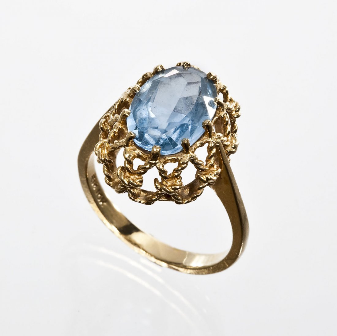 10K Gold & Simulated Aquamarine Ring: DESCRIPTION: Marked 10K yellow gold ring set with one approximately 12mm x 8mm oval faceted simulated aquamarine in a filigree style setting. Size 6. 2.3 dwt (3.6 gr).