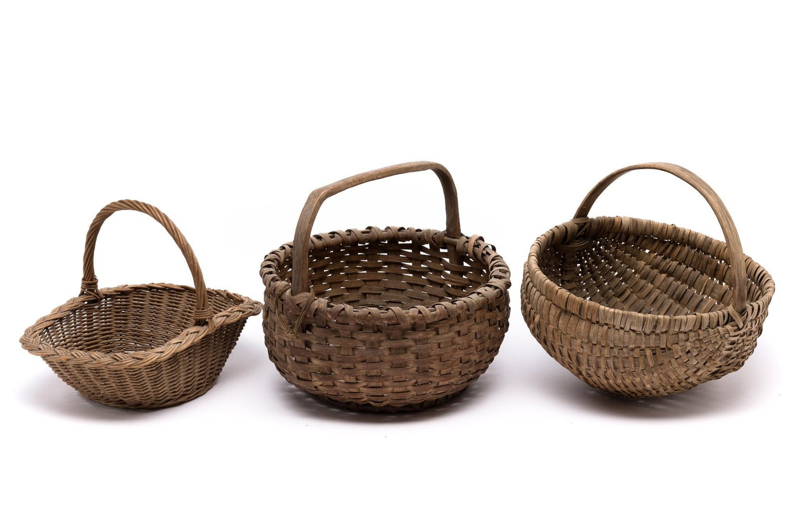 3 Vintage and Antique Baskets: Overall wear consistent with age. No major breaks in woven material. Smallest is 9-1/2" wide x 12-1/2" long x 4" deep x 9-1/2" tall with handle. Largest is 13" diameter x 5-1/2" deep x 11-1/2" tall wi