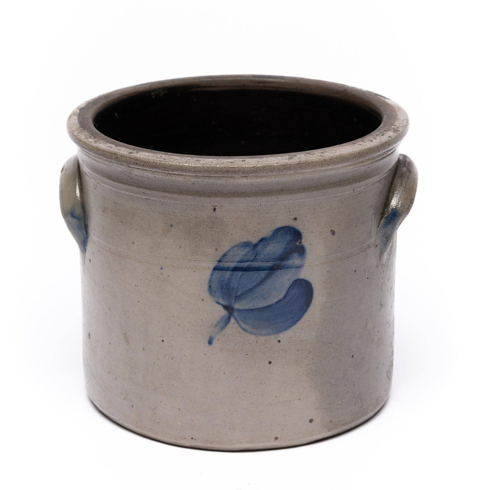 Stoneware Crock with Floral Design: C. 19th century. Floral motif at center. Light blue glaze over lug handles. 7" tall x 8" diameter. Overall good condition with some discoloration.