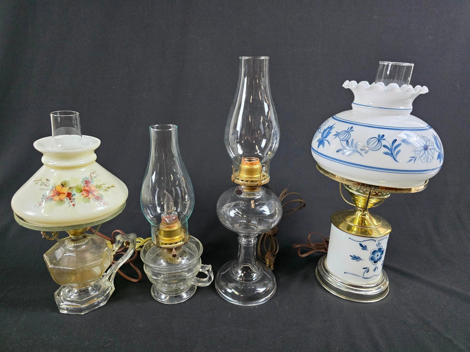 4 Electrified Oil Lamps: NOT ELIGIBLE FOR IN-HOUSE SHIPPING. Includes blue & white milk glass Blue Onion Lamp, and more. All with normal wear and tear consistent with age. 13" to 16" tall overall.