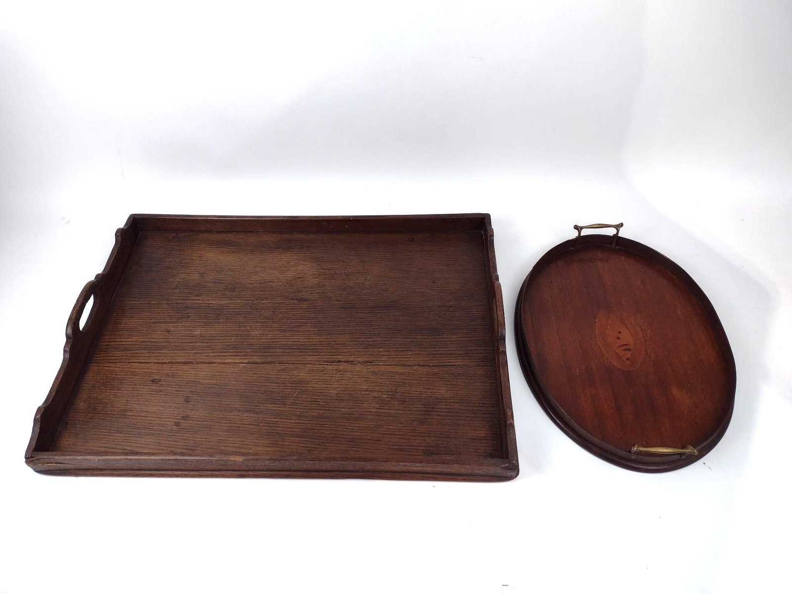 2 Wood Trays: NOT ELIGIBLE FOR IN-HOUSE SHIPPING. One with inlaid seashell. 12-1/4" to 19-3/4" wide x 17-3/4" to 27-1/4" long. Crack to one side of one tray.