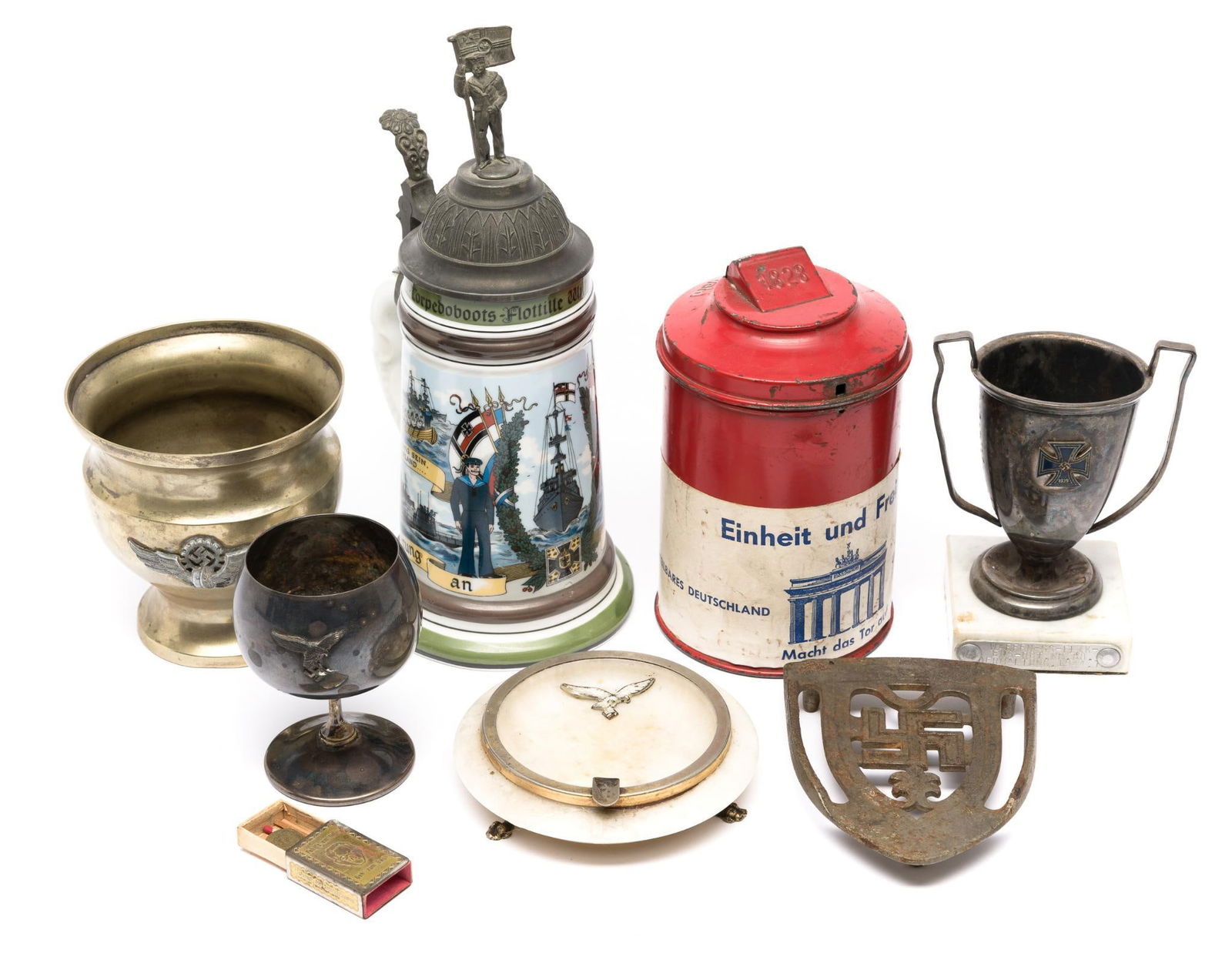 Various WWI WWII Era Objects: Beer stein WWI, Donation can, Trivet, stone ashtray, matchbox, trophy cup, others. Ranges of object sizes include the WWI beer stein 10 1/2" height, marble ashtray 5" diameter, brass pot 4 3/4" height
