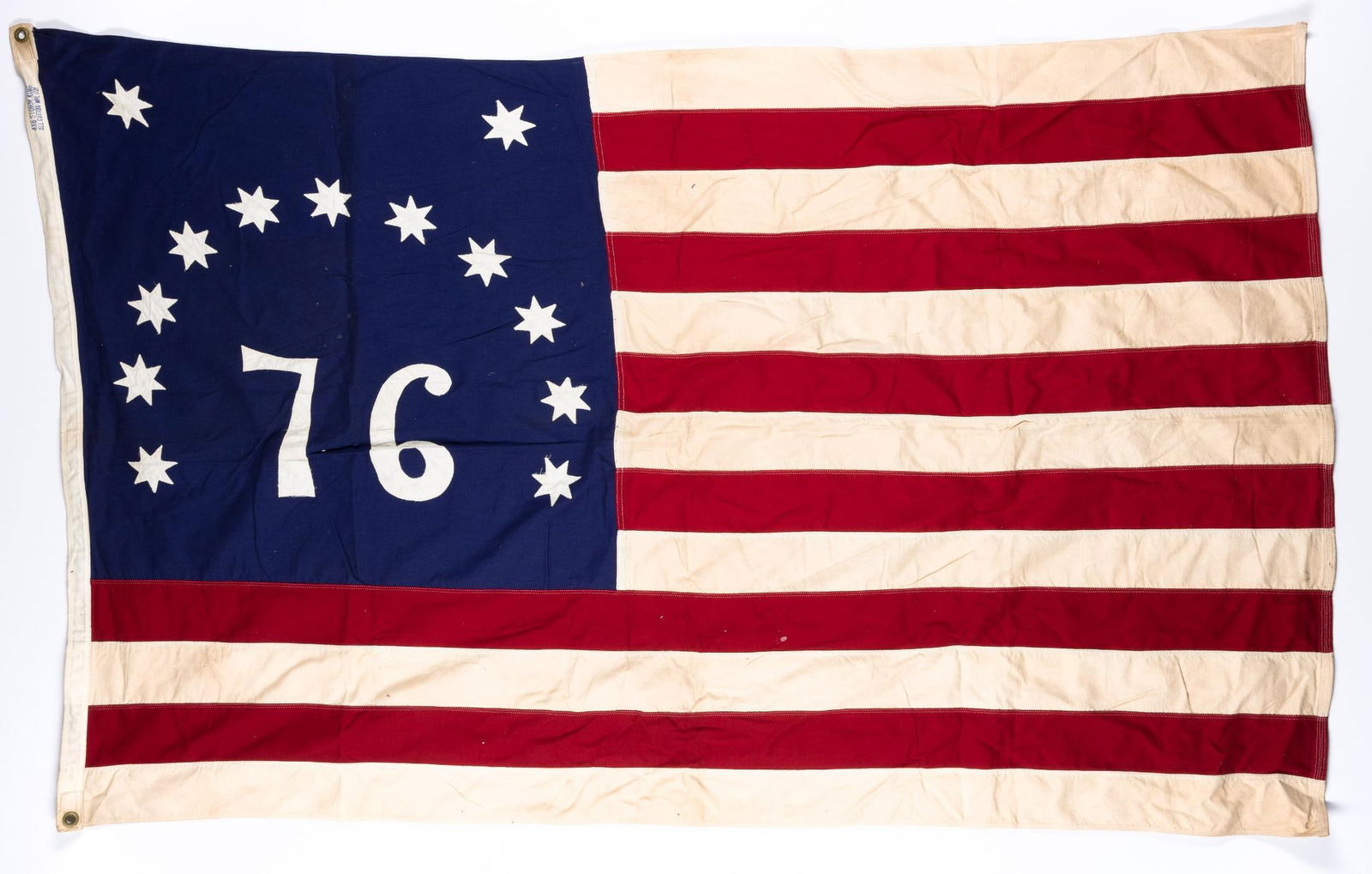 2 '76 American Flag: DESCRIPTION: Both flags marked '76. One marked Defiance on edge. MEASUREMENT: 4' to 6' wide. CONDITION: Sun fading on one of the flags.
