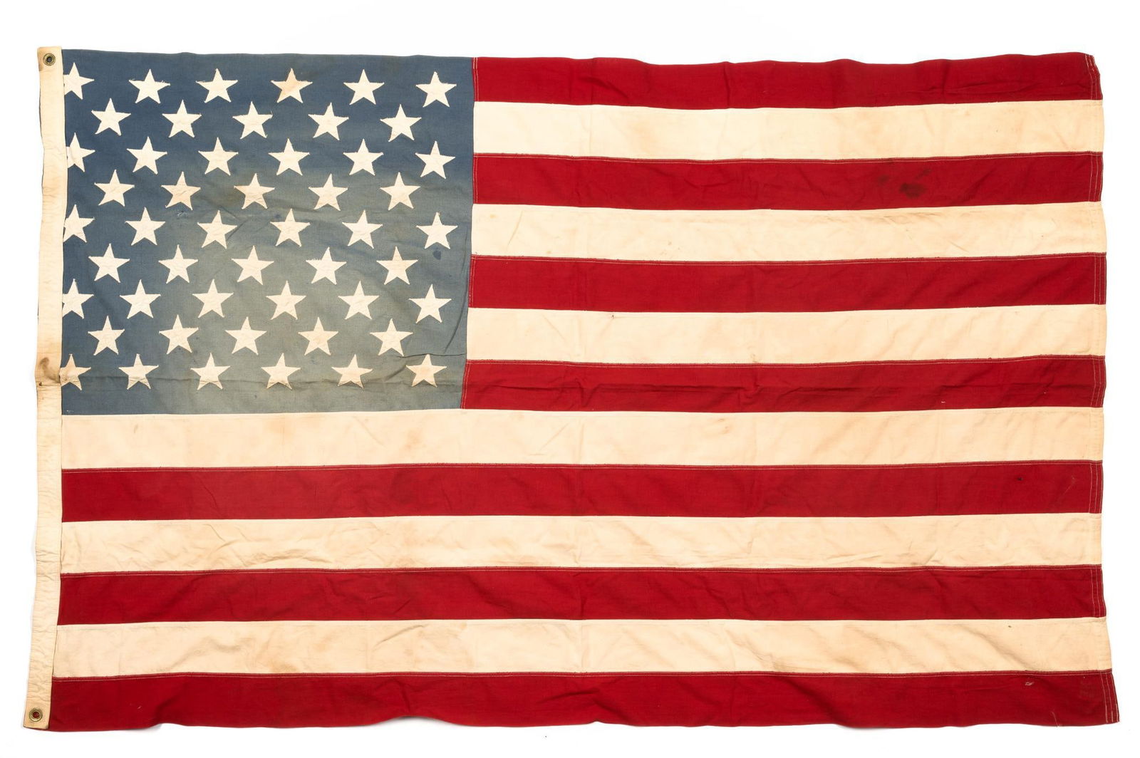 Large American Flag: DESCRIPTION: Fifty star American flag. Some stars are cut off by the edge of the flag. CONDITION: Some fading consistent with use.