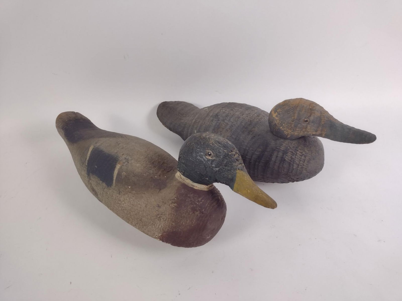 2 Wood Carved Duck Decoys: Both unsigned. 16" to 16-1/2" long. Both with losses consistent with age and use. PROVENANCE: This lot was consigned by the former Double Eagle Antiques on North Second Street in Harrisburg, PA.
