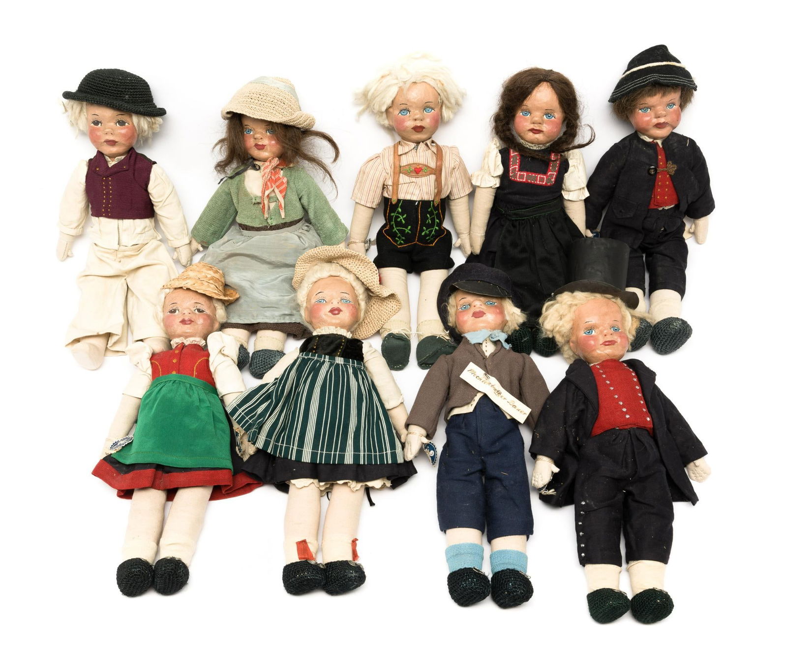 9 Puppen Reform Movement Kaulitz Style Dolls: DESCRIPTION: Nine German Puppen Reform Style dolls in various German provincial costume. Molded papier mache heads. Hand-painted faces . One with a blue and white tag marked "M." Two have handwritten