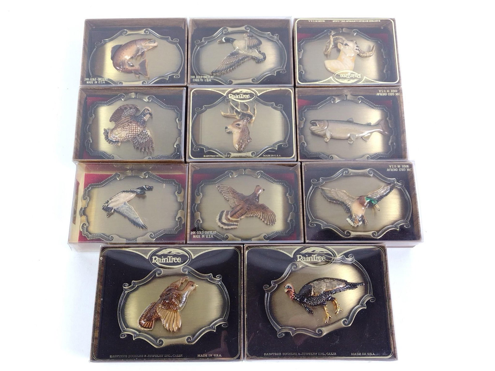 11 Rain Tree Buckle and Jewelry Inc 24 K Gold Overlay Belt Buckles: All with original boxes. Each approximately 3-1/2" wide x 2-1/2" high.