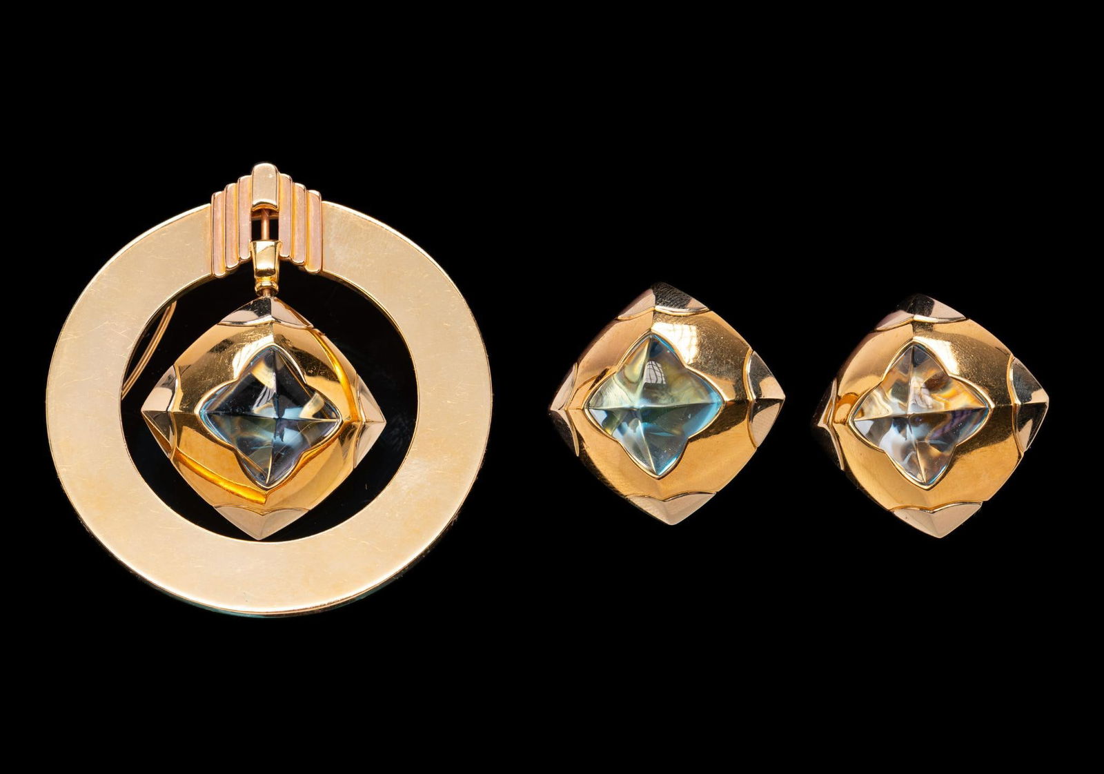 Gallen Benson 14K Gold & Blue Topaz Slide Pendant and Ear Clips: DESCRIPTION: Yellow gold slide pendant and ear clips each set with blue topaz. Signed. MEASUREMENTS: Brooch 2-1/4”, ear clips 1”. Total weight 70.8 grams.