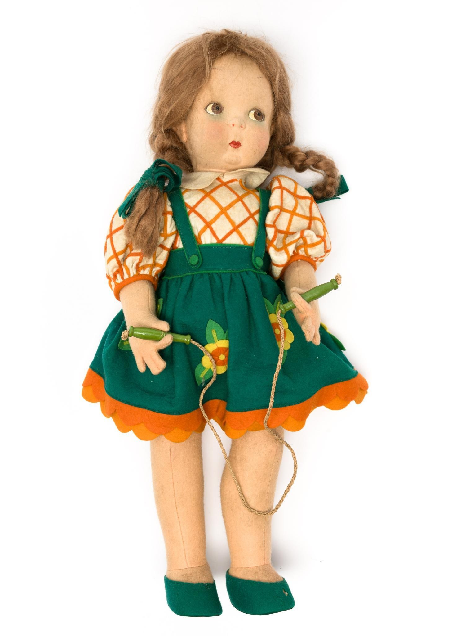 Lenci Frida Doll: DESCRIPTION: Felt doll with jumping rope. Green dress with flowers. With original paper tag attached. Felt body with felt clothing. PROVENANCE: From private collection. MEASUREMENTS: 21-1/2" long. CON