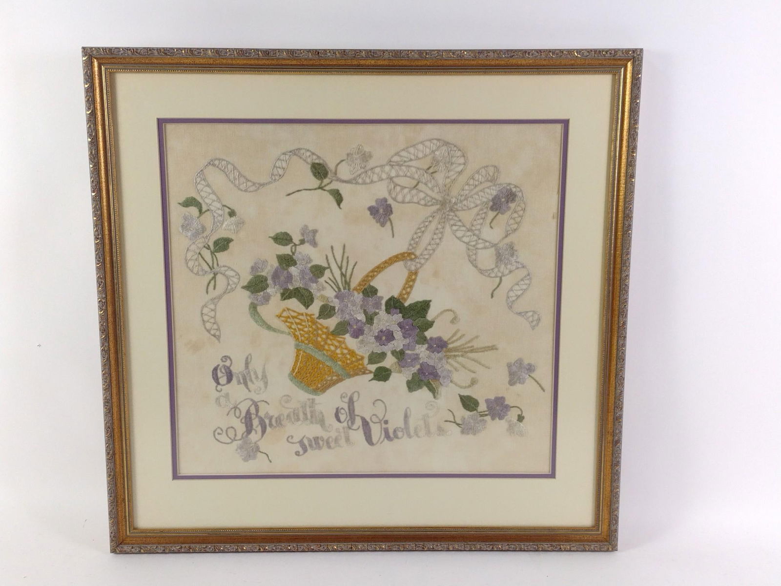 "Only Breath Of Sweet Violets" Needlepoint: NOT ELIGIBLE FOR IN-HOUSE SHIPPING. Sight: 17-1/2" high x 19" wide. Overall with frame: 25" high x 25-3/4" wide. Some staining throughout linen.
