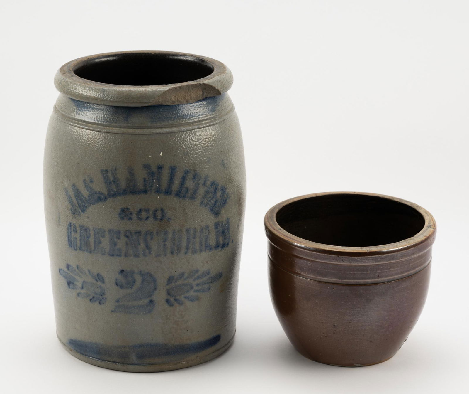 2 Stoneware Crocks: One marked J.A.S Hamilton & Co. Greencastle, with loss to rim. Measure 7" to 7-1/4" wide x 5-5/8" to 11-1/2" high.