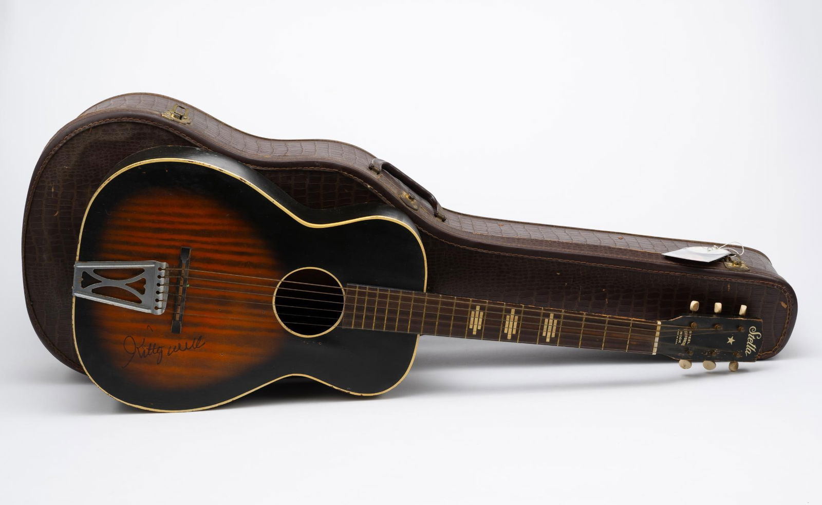 Kitty Wells Autographed Acoustic Guitar with Case and Collector Card: NOT ELIGIBLE FOR IN-HOUSE SHIPPING. Overall: 13-1/2" wide x 36" long. Autograph is not authenticated. Provenance: Per consignor - played and signed by Kitty Wells. Guitar has a split down the back boa