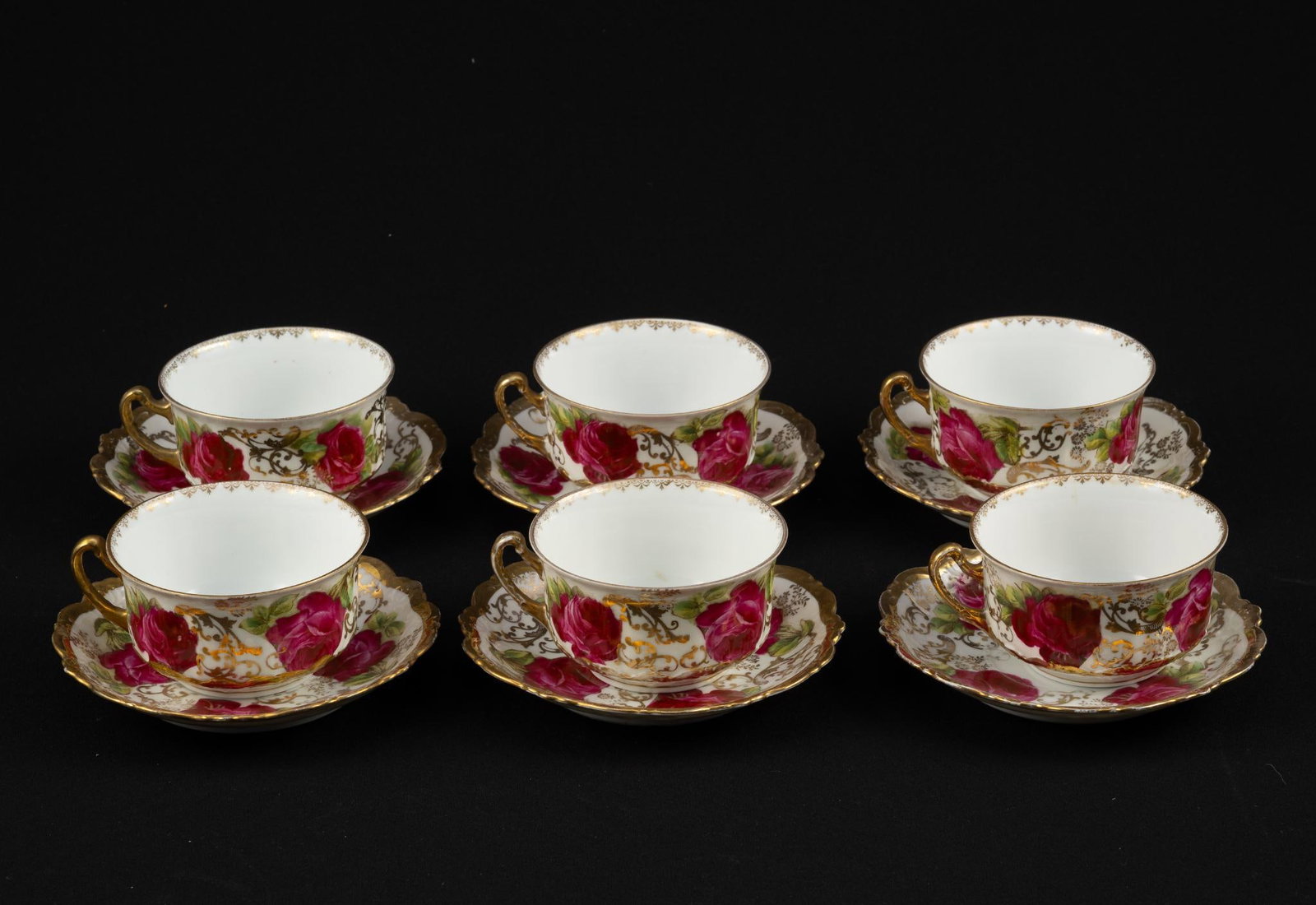 12 Royal Austria Cups and Saucers: Includes 6 cups and 6 saucers. Saucers: 5-3/4" diameter. 2 saucers with cracks (1 hairline and 1 spider crack). 2 cups with hairline cracks from top rim.