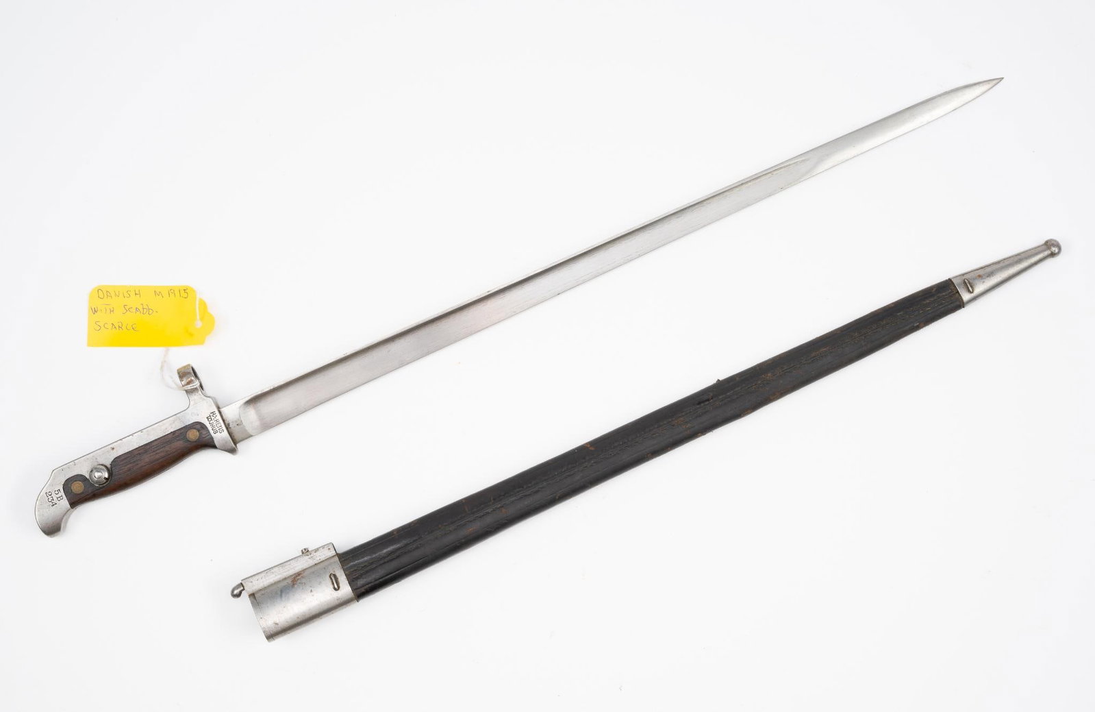 Danish M1915 Bayonet: NOT ELIGIBLE FOR IN-HOUSE SHIPPING OUTSIDE THE UNITED STATES. With scabbard. Hilt marked Harens Tohjus 114424. 22-3/8" long.