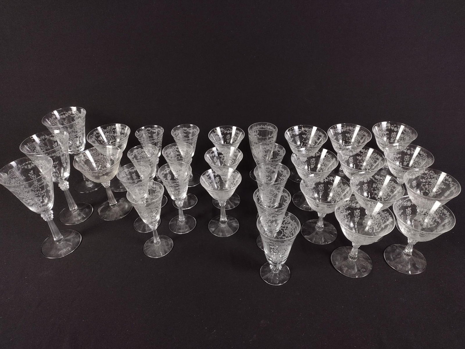 26 Pcs Fostoria "Romance" Etched Stemware: DESCRIPTION: Includes three water goblets, two long stem champagne/sherbet glasses, seven wine goblets, one ice tea glass, three champagne/sherbet glasses, five tumblers, and eleven low champagne/sher
