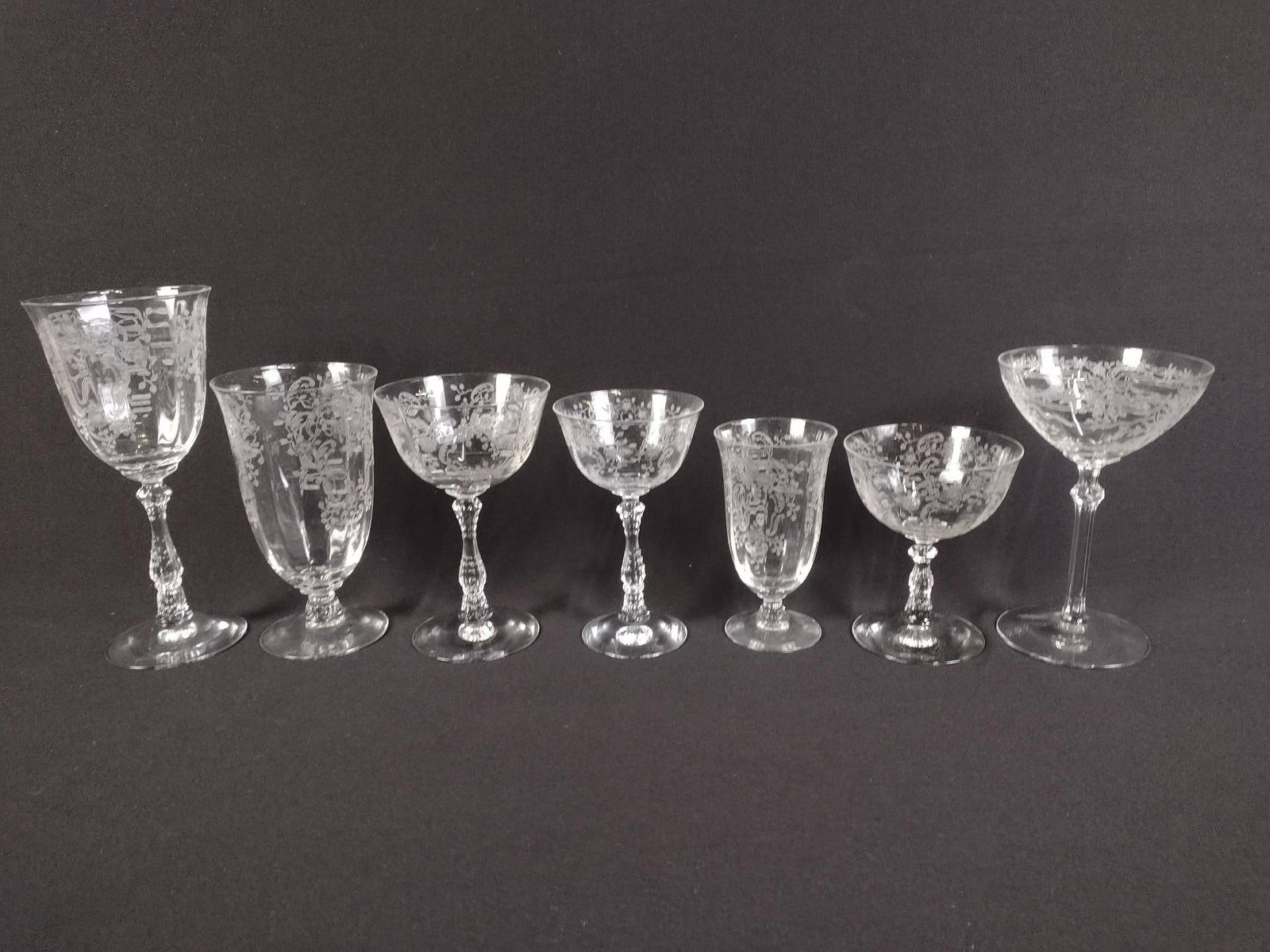 55 Pcs Fostoria Etched Glassware: DESCRIPTION: Includes seven "June" champagne glasses, one "meadow rose" claret wine, eight "meadow rose" ice tea glasses, eleven "meadow rose" champagne glasses, six "meadow rose" smaller champagne gl