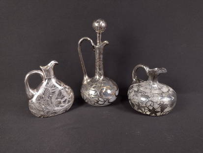 3 Silver Overlay Decanter Pcs: DESCRIPTION: Includes three silver overlay decanters one with a grape vine design, one with a wheat design with a F on it, and one with a R on it and has a stopper. MEASUREMENTS: From 6" to 12" tall.