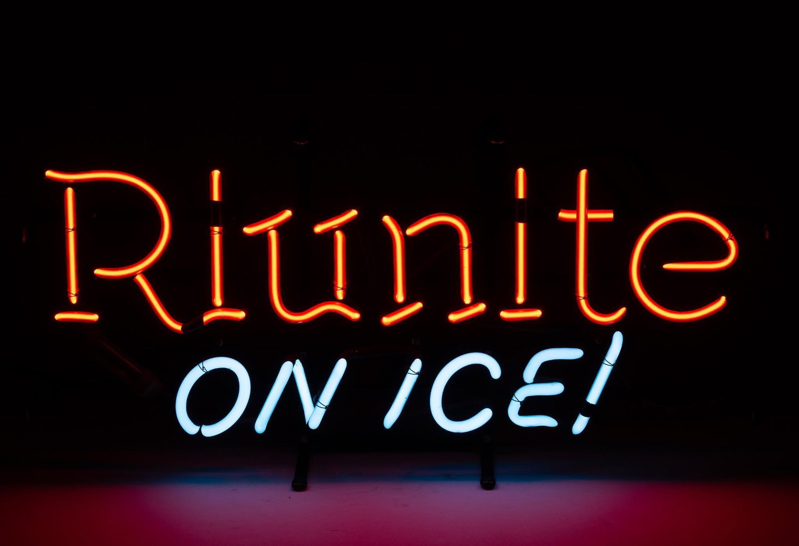 Riunite On Ice Neon Sign: NOT ELIGIBLE FOR IN-HOUSE SHIPPING. Working. Overall: 23-1/4" wide x 6-1/2" deep x 11-1/4" high. PROVENANCE: From the Collection of Robert L. Hassenplug—a proud veteran and small business owner was 