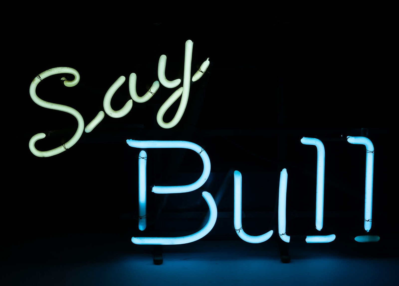 Say Bull Neon Sign: NOT ELIGIBLE FOR IN-HOUSE SHIPPING. Working. Overall: 18" wide x 6" deep x 11-1/2" high. PROVENANCE: From the Collection of Robert L. Hassenplug—a proud veteran and small business owner was an avid