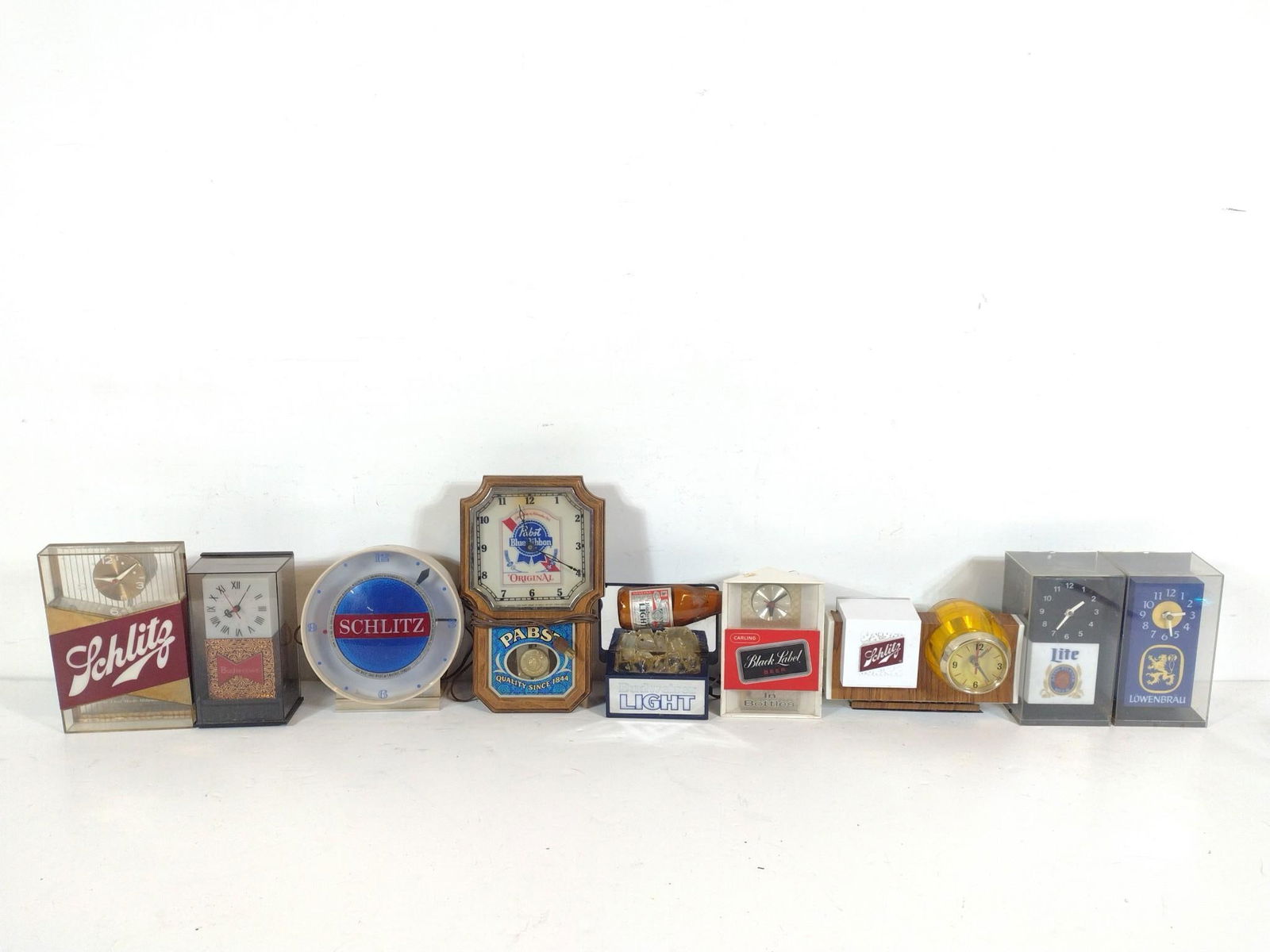 10 Beer Advertisement Clocks incl. Schlitz: NOT ELIGIBLE FOR IN-HOUSE SHIPPING. Also includes Pabst; Bud Lite; and more. Not tested. 5-1/4" to 11-1/2" wide x 7" to 9-1/4" high. PROVENANCE: From the Collection of Robert L. Hassenplug—a proud v