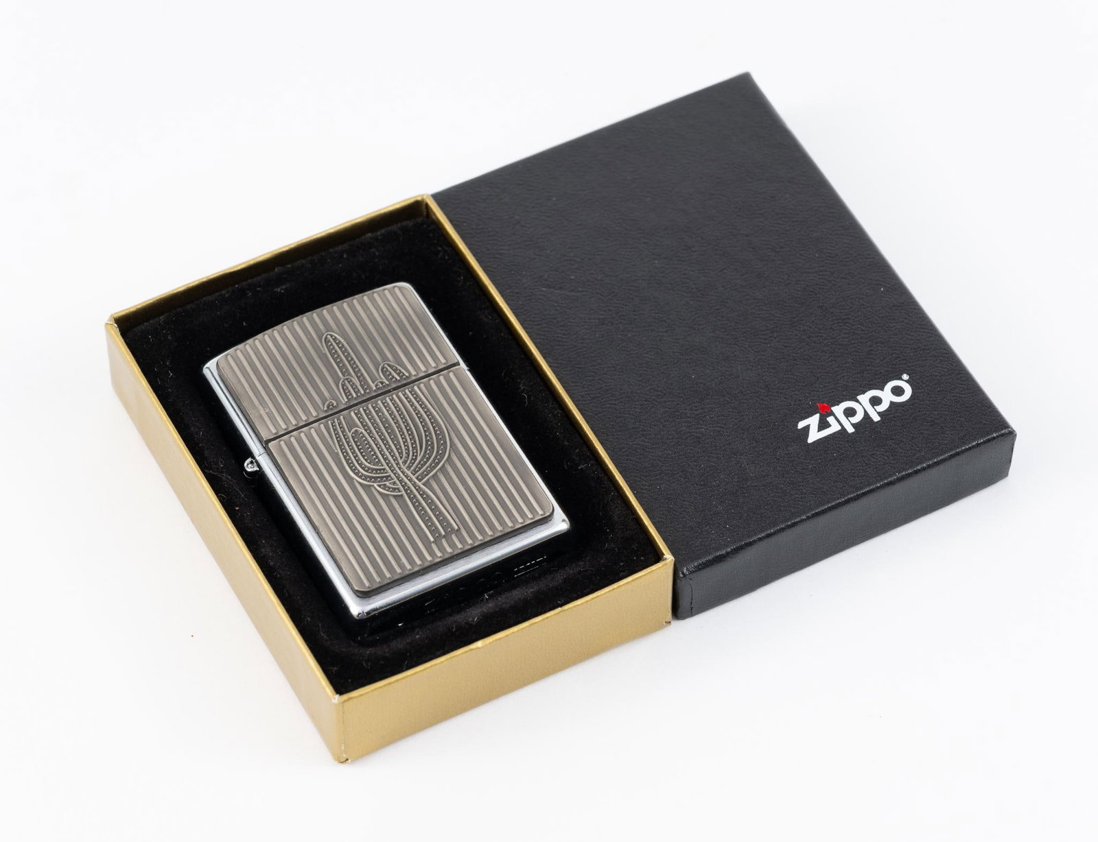 Zippo Saguaro Cactus Lighter: In Zippo box. Lighter has not been opened or used. 2-3/8" wide x 3-1/4" long.