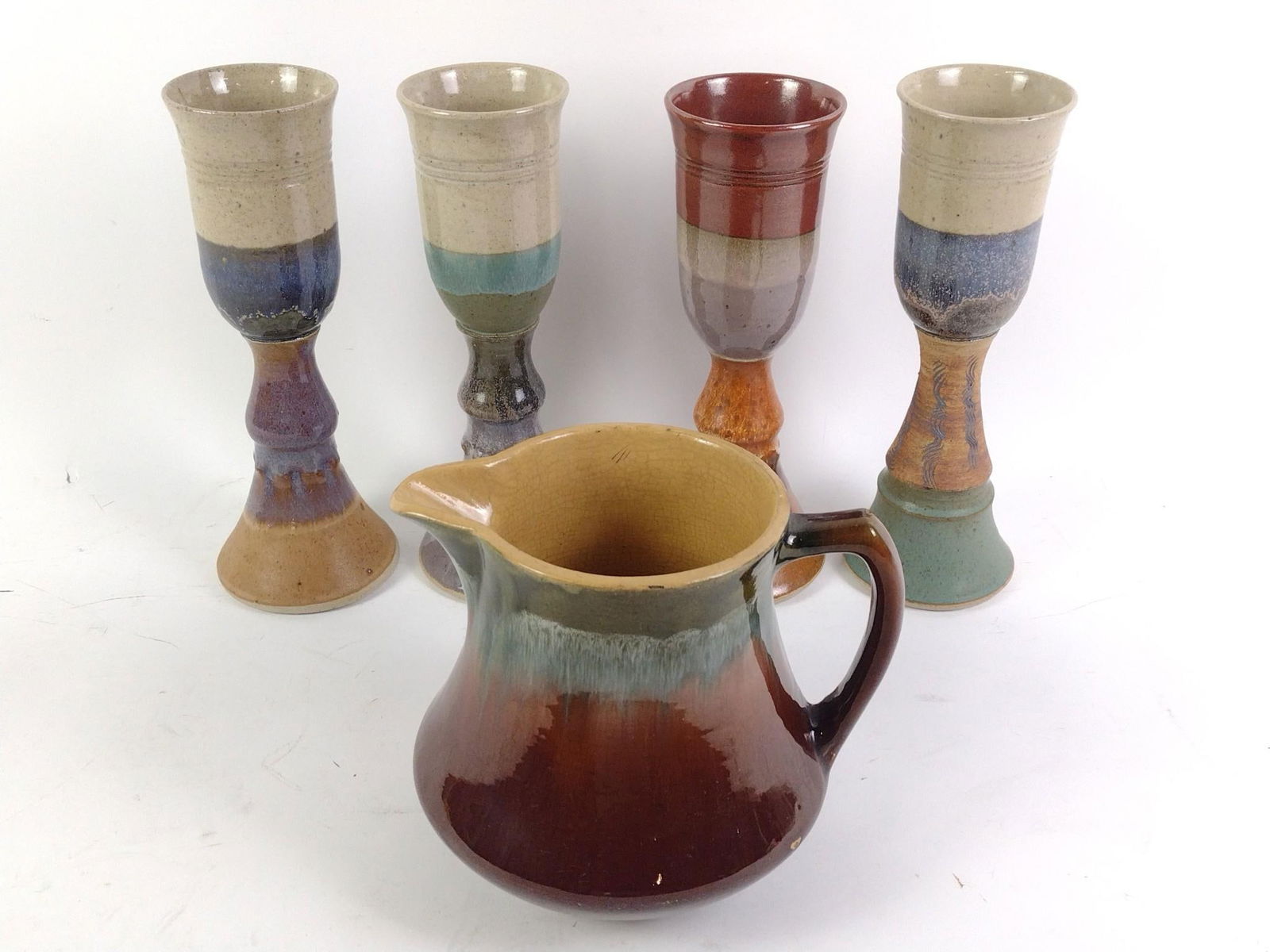 Set of 4 Vintage Signed Art Pottery Goblets w/ Pitcher: Includes set of 4 vintage signed goblets by Hair. Also includes vintage pitcher, unsigned with drip glaze. Goblets -- 11" high. Pitcher is 7-1/2" x 10". Chips to pitcher, but goblets in good condition