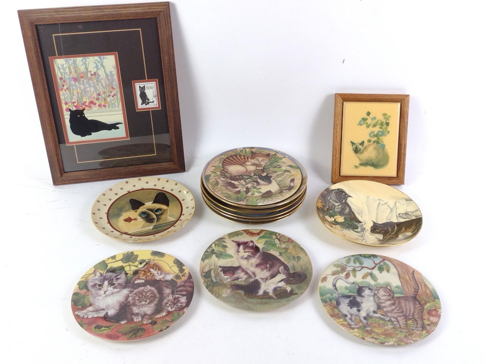 Lot of Cat Plates and Decorations: 2 framed decorations and 11 plates depicting cats of various styles. Largest plate is 7-1/4" in diameter and the largest framed decoration is 13-3/4" tall and 10-3/4" wide.