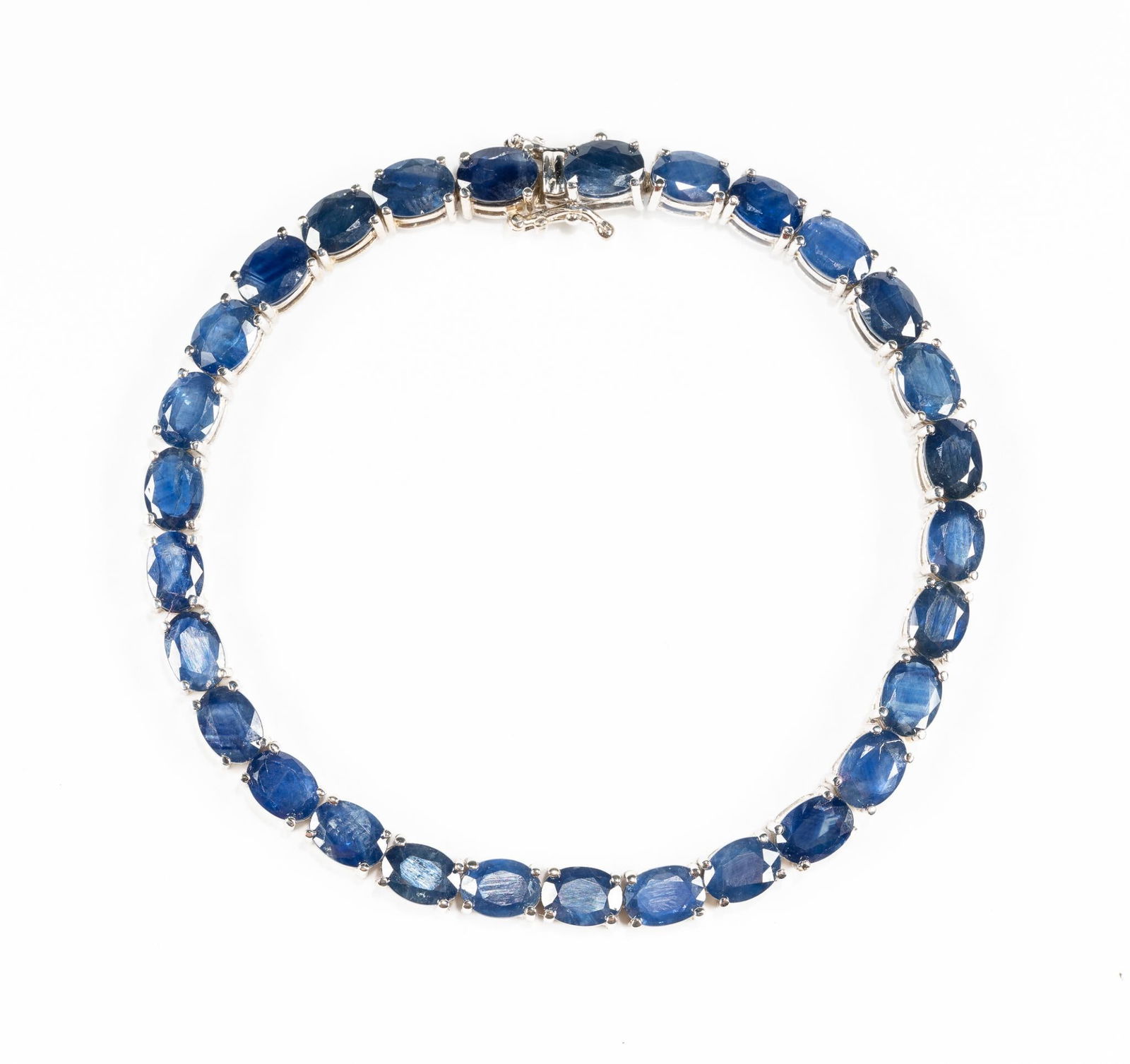 14K Gold And Blue Sapphire Bracelet: The bracelet is 14k white gold with 22 carats of blue sapphire gemstones. It is 8" in length and weighs 18.4 grams. It is in new condition.