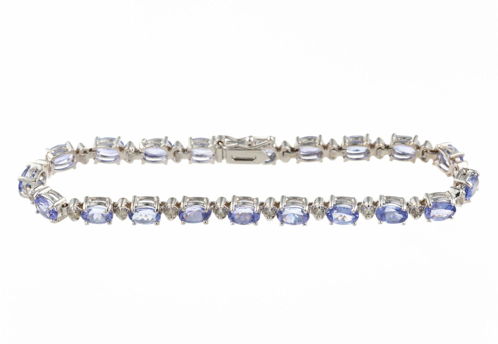 14K Gold Gemstone And Diamond Bracelet: A 7 1/2" length white gold bracelet with oval tanzanite and round diamonds in an alternating line pattern. Total weight is 13.4 grams and it is in new condition.