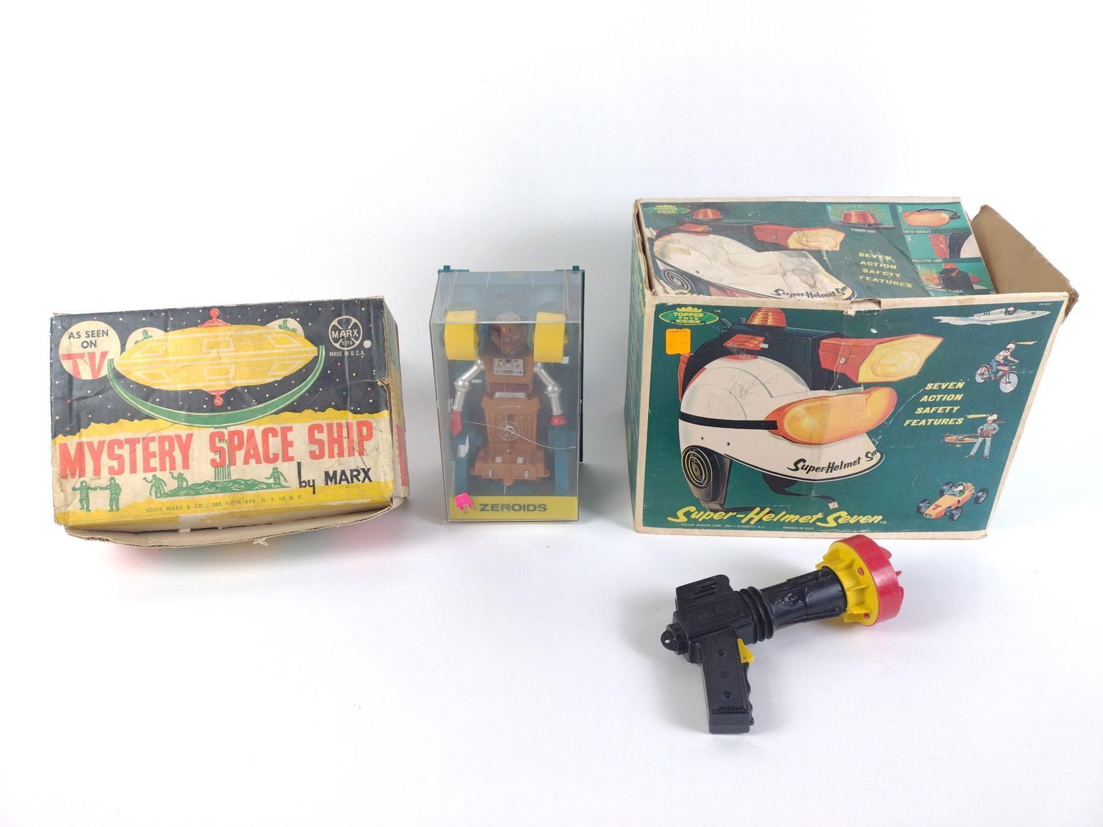 Tim Mee Toys z/Sonic Ray Laser Gun, Mystery Space Ship by Marx: 1) Mystery Space Ship in box, missing piece. 2) Super-Helmet Seven, in box. 3) Vintage Ideal Zeroid Robot Zobor. 4) Laser Ray toy. From 4-1/2" to 9-3/4" tall and 5" to 12-3/4" wide.
