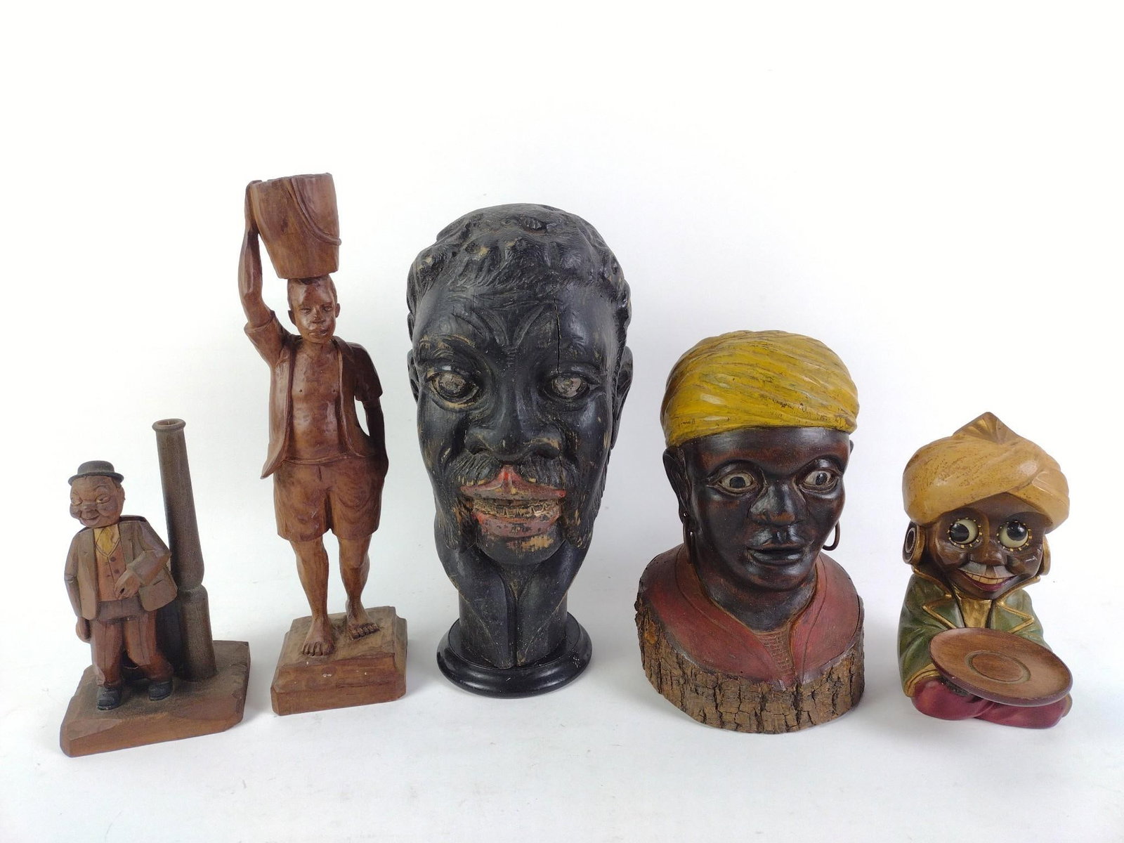 5 Carved Wood Black Americana Sculptures: One marked Y. Exorphe. One is a clock. General wear and tear associated with age. From 7-1/2" to 13" tall and 3-1/2" to 7" wide.