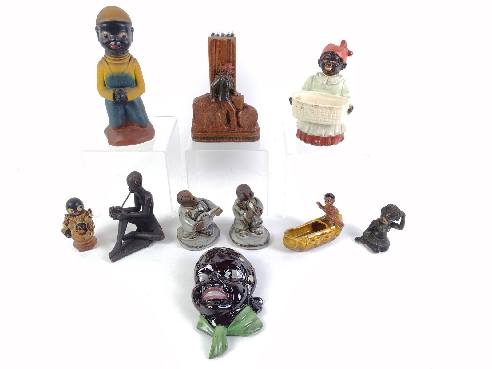 10 Black Americana Figurines: Includes carved wood brush holder. Woman holding basket, face wall hanging, and person on boat all needed repair work. From 3-1/2" to 9" tall and 1-3/4" to 5" wide.