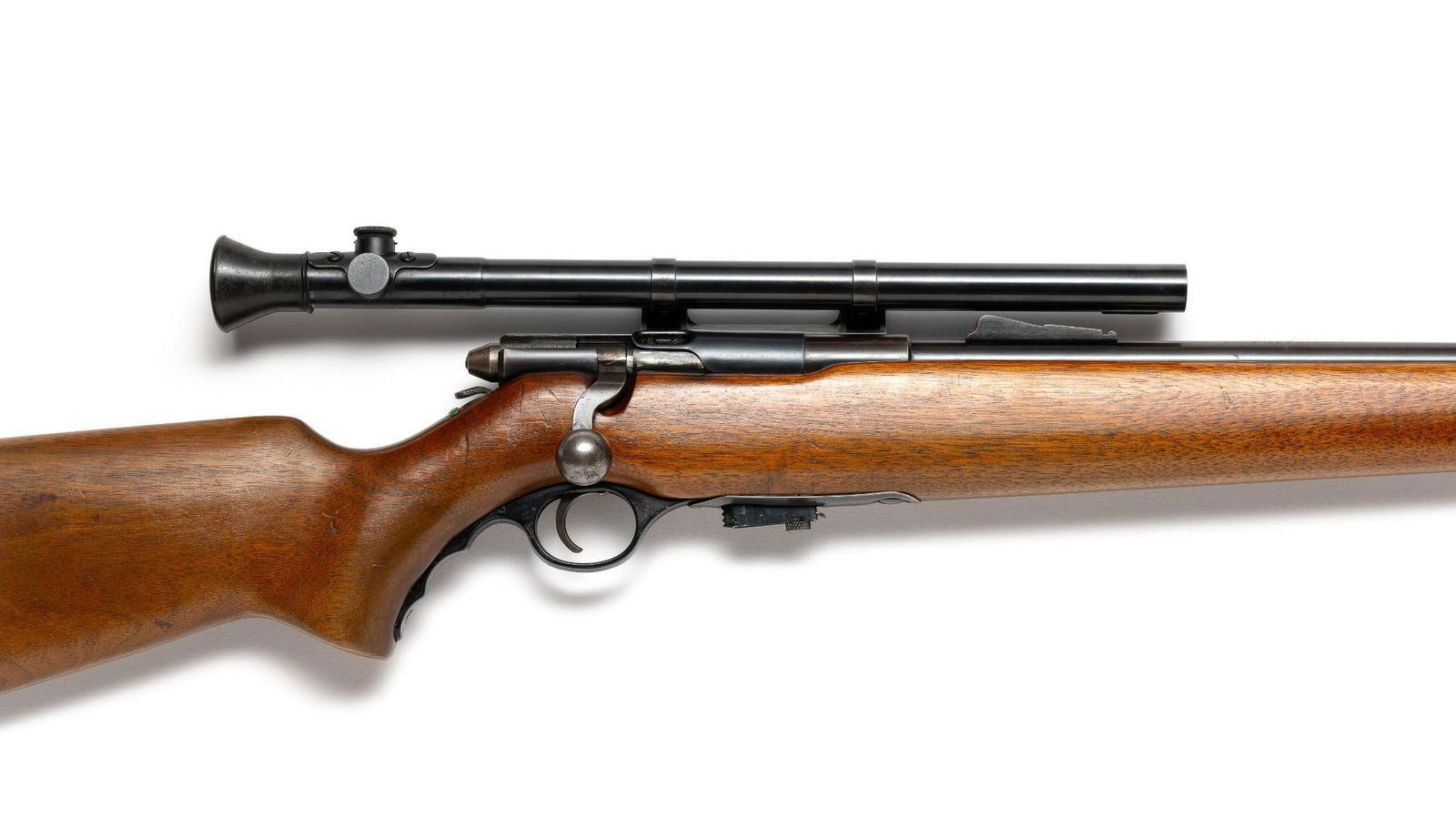 Mossberg Model 42M-C .22 S - LR Rifle: A Mossberg bolt action .22 short and LR equipped with Mossberg Number M4c scope. The gun has signs of woodwork preservation and other signs of use. Produced from 1947 to 1950 as a military training ri