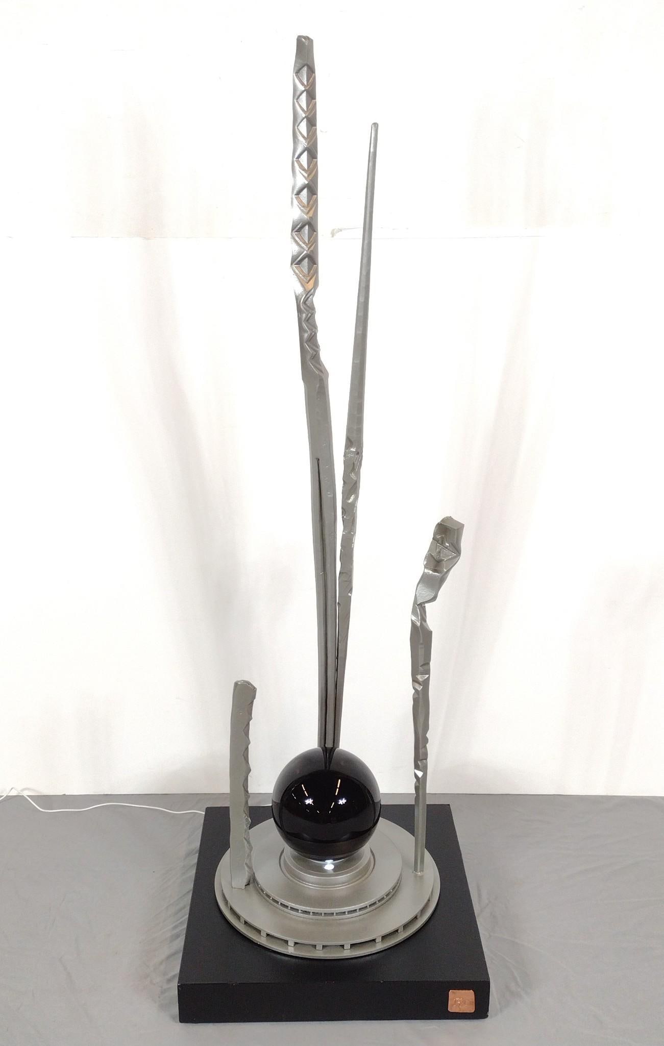 "Comet" Steel Sculpture By James Cavagnaro: NOT ELIGIBLE FOR IN-HOUSE SHIPPING: See Terms for Shipping Options. 20" wood base. 7.5" diameter obsidian sphere lit from below. 60-1/2" high. ARTIST STATEMENT: James Emmanuel Cavagnaro, G.G., is a li