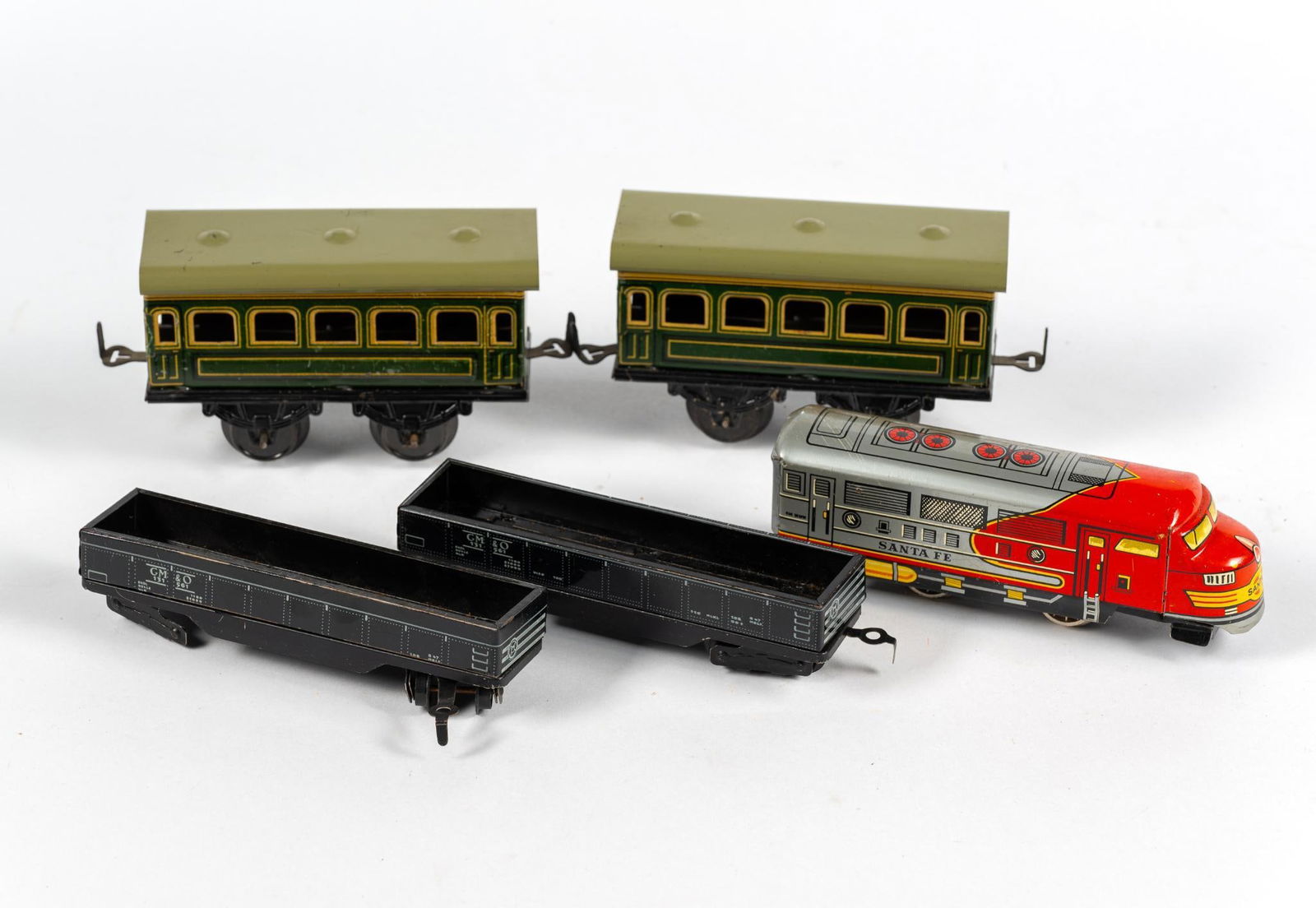 5 Antique German Tin Lithograph Train Cars: Includes (2) passenger cars marked "KB Made in Germany." Also includes (2) flatbed tin cars marked "Made in Western Germany." Lastly, includes a Santa Fe Diesel Engine marked "Made in Germany." 5" to