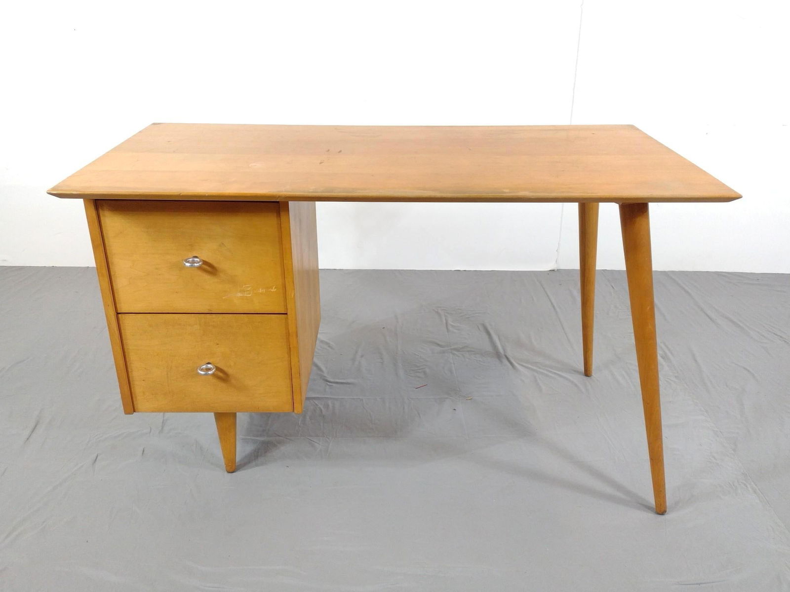 Paul McCobb "Winchedon Modern" Mid Century Modern Two Drawer Desk: NOT ELIGIBLE FOR IN-HOUSE SHIPPING - See Terms for Shipping Options. No. 1560 Birch Desk. 48" wide X 24" deep X 29-1/2" high. Has some scratches. Top has areas of finish loss. PROVENANCE: From the Est