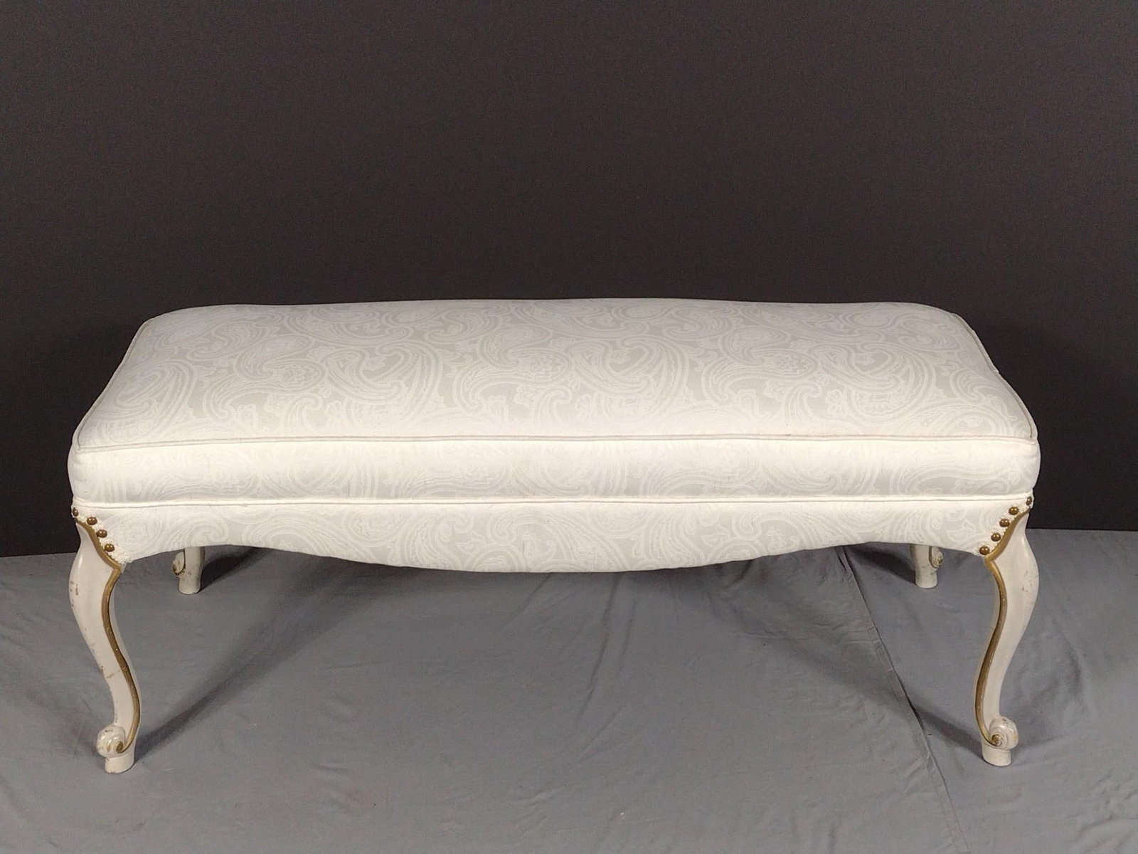 White Upholstered Bench: NOT ELIGIBLE FOR IN-HOUSE SHIPPING - See Terms for Shipping Options. 44" wide X 18-1/2" deep X 20" high. No manufactures name found. PROVENANCE: From Kunkel Estate in Harrisburg, PA.