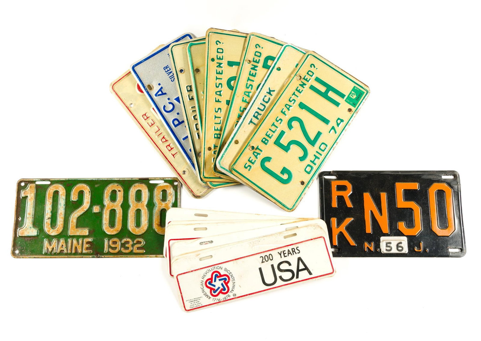 11 Vintage United States License Plates plus Commemorative Plates: 8 Ohio (1974-1979), 1 Maine (1932), and 2 New Jersey (1956). Also includes 6 commemorative American Revolution Bicentennial cardboard plates. Normal wear and tear associated with age, including paint