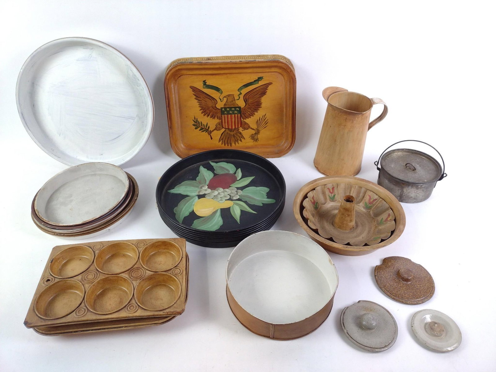 Grouping of Vintage Cooking Pans and Trays: Primitive style. Some painted plates and trays. Also includes miscellaneous lids and a tin cup. Some of the paint is peeling. From 5-1/2" to 13-3/4" wide and 1" to 8-1/2" tall.