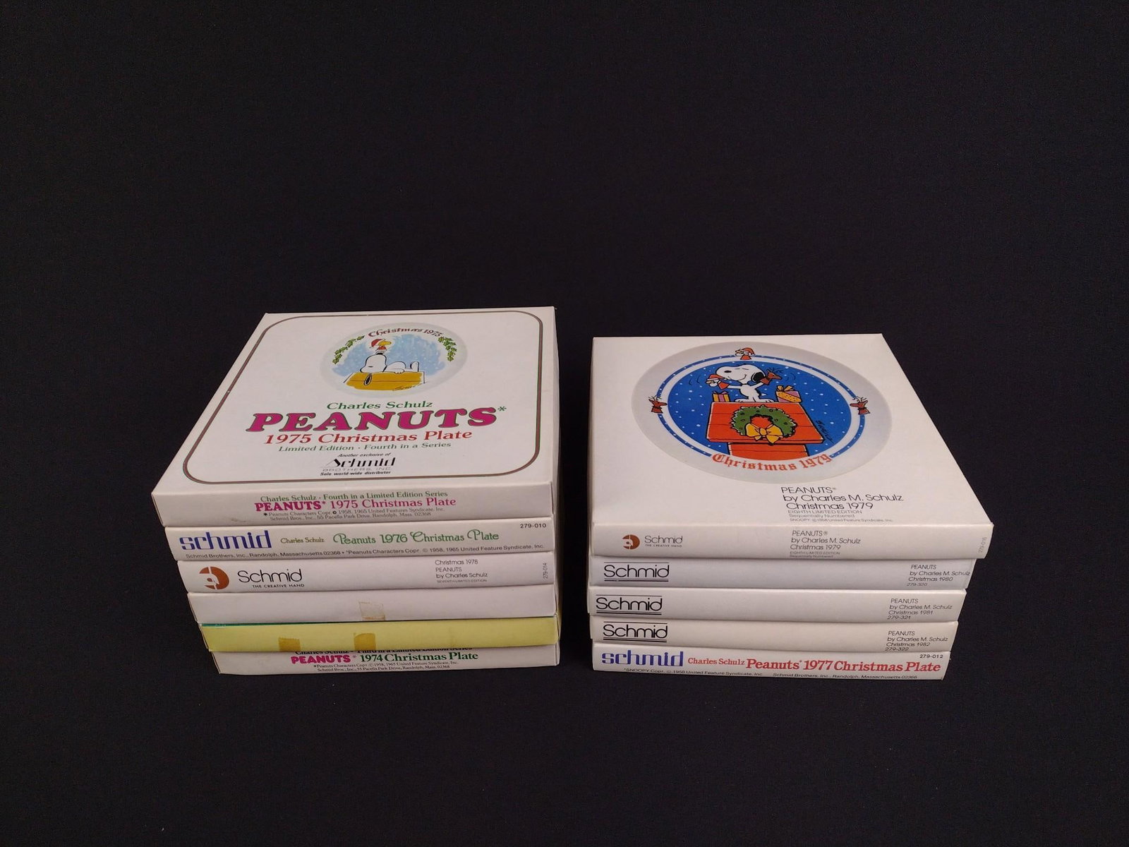 11 Peanut Christmas Collector Plates in OBs: Includes 1972-1982. All measure 8" wide x 8" deep x 1" high.