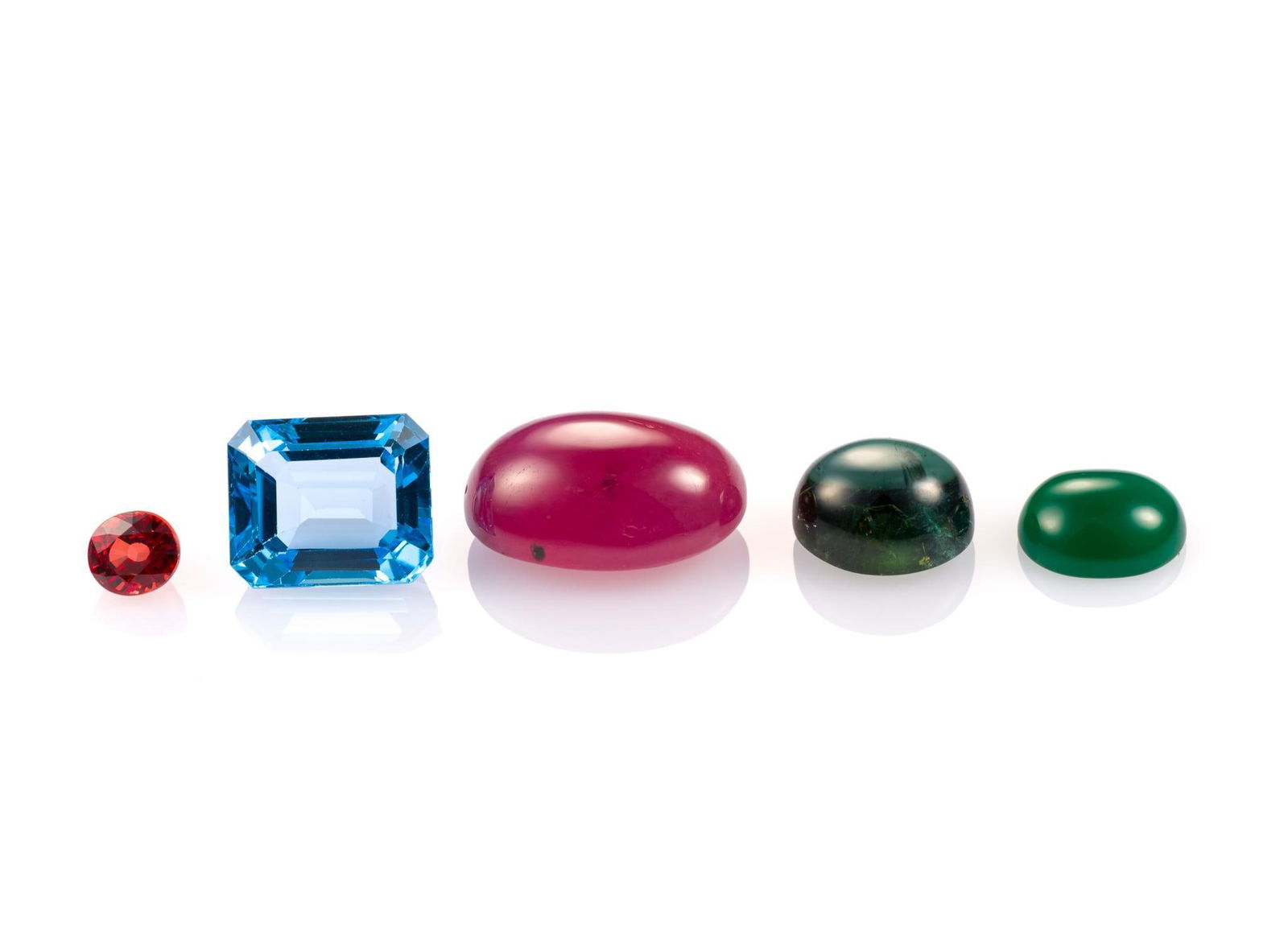 5 Unmounted Stones: Includes (1) Chrysoprase, oval cabochon, 2.51 carats, translucent, natural; (2) Tourmaline, oval cabochon, 5.46 carats, SI, natural; (3) Ruby, oval cabochon, 16.58 carats, SI, heated; (4) Topaz, emera