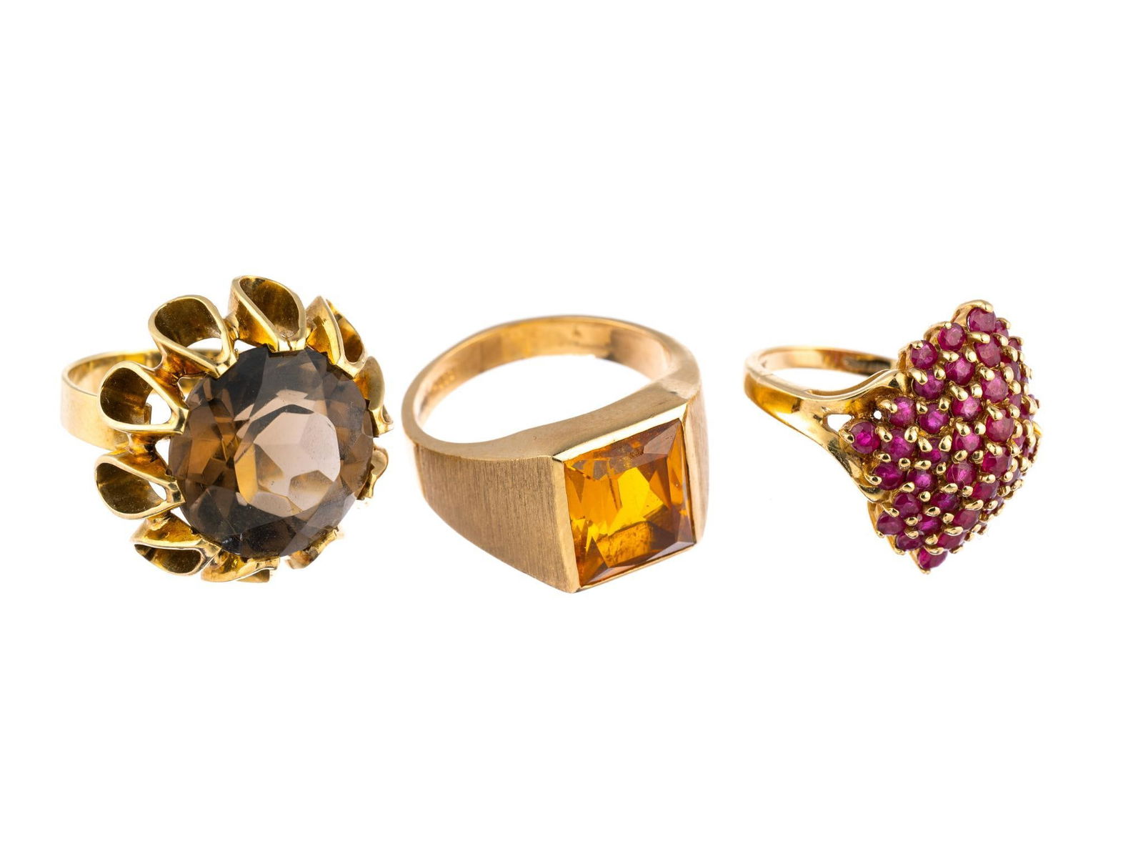 Three Rings 14K Gold and 10K: One ring, 14k yellow gold, size 7.5, with open teardrop designs and quartz gemstone weighs 9.7 grams. A second size 6 ring in 10K gold with a melee arrangement of ruby (like) gemstones 6.1 grams, and