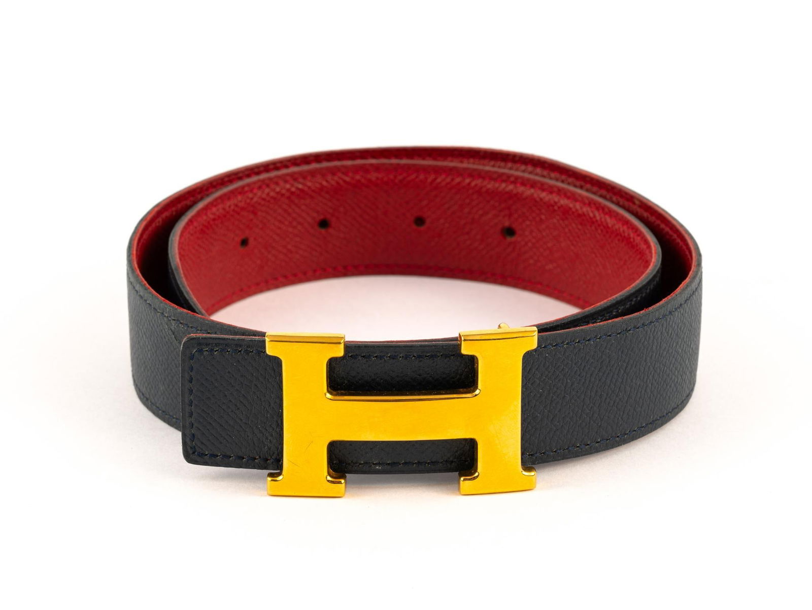 Hermes Leather Belt Reversible: The belt is signed Hermes Paris and the buckle is signed Hermes and with a hallmark. The belt has one line of damage to the black side. 27" to 24" usable size across the four hole range.