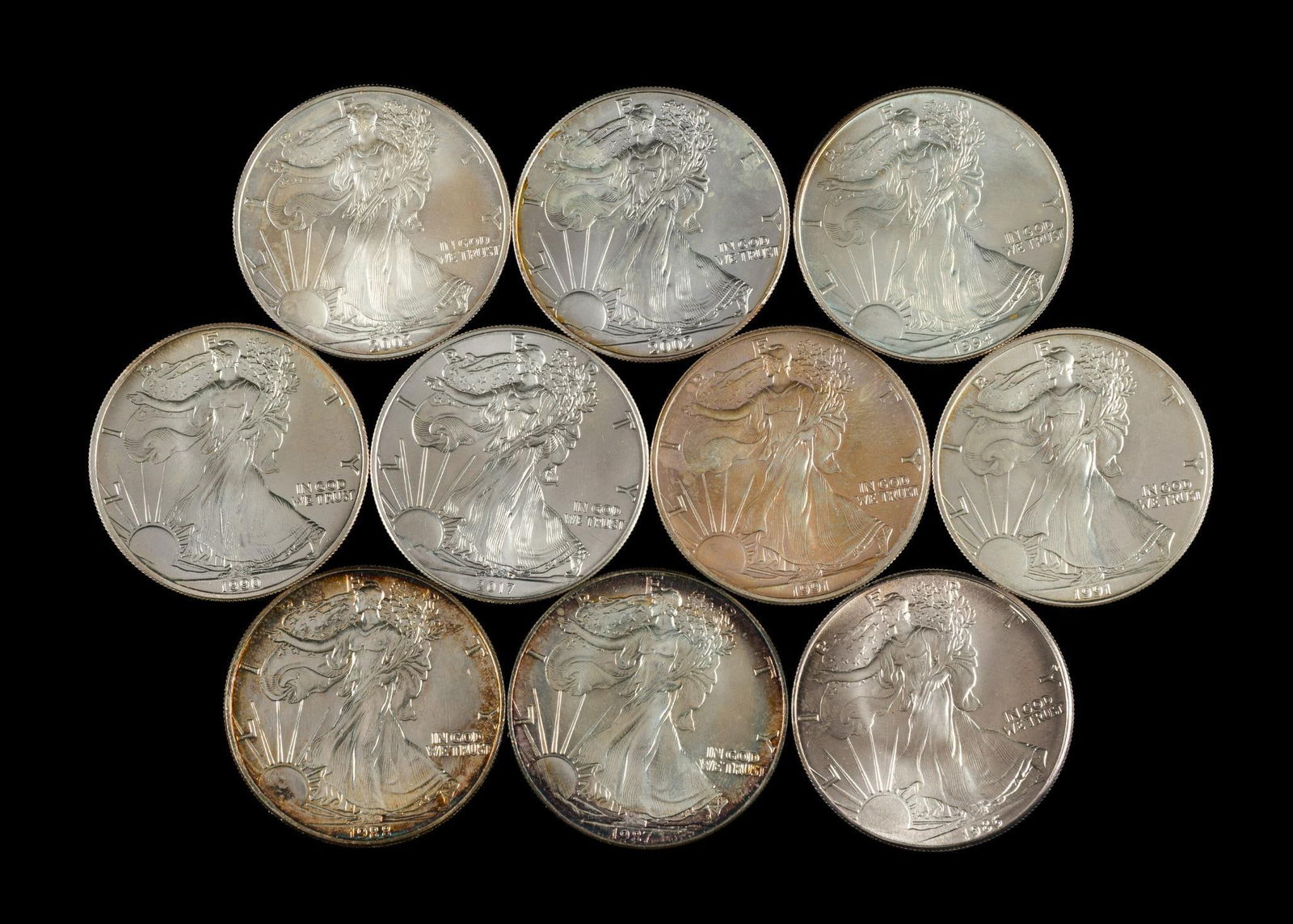 Ten Silver American Eagle Dollars: Dates are 1986, 1987, 1988, 1990, 1991, 1991, 1994, 2002, 2003, 2017.