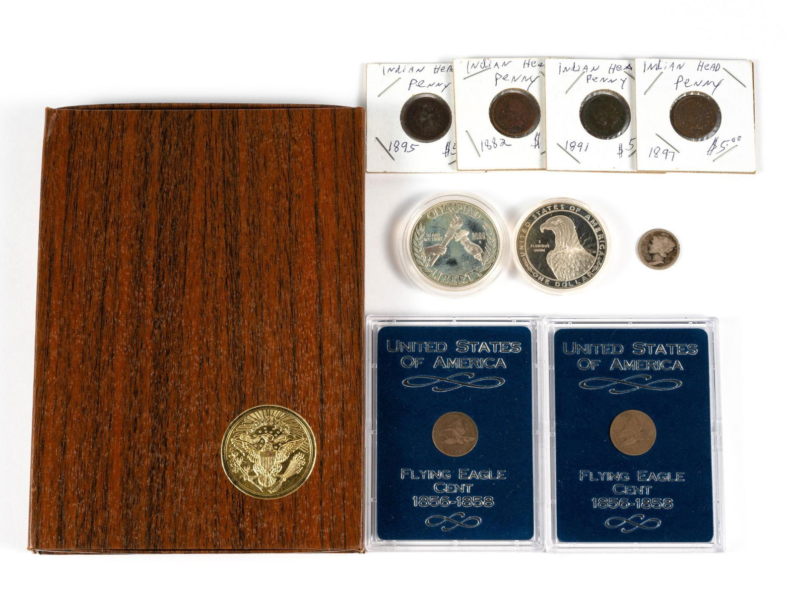 Various United States Coins Including Silver: Two Flying Eagle cents, four Indian Head cents, two silver dollars Olympics 1983 and 1988, one silver brown case Eisenhower dollar (40% silver), one 1916 Mercury dime.
