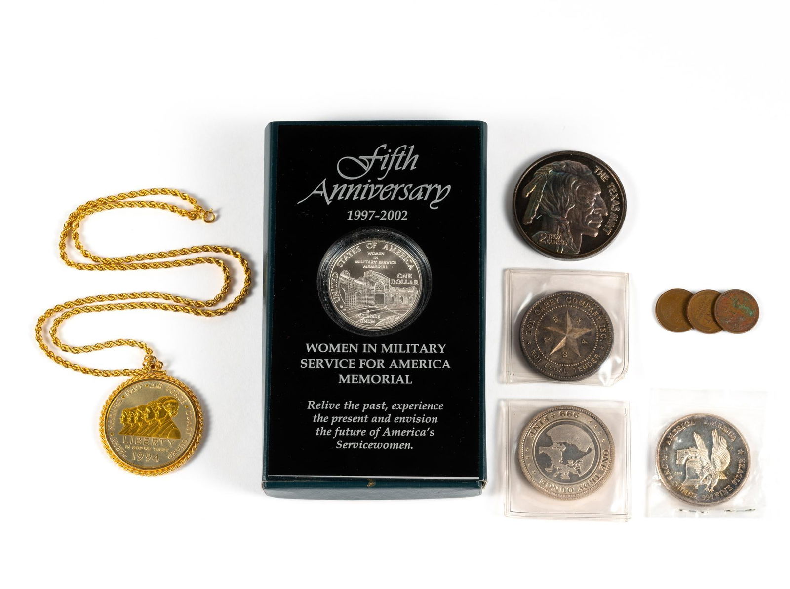 Silver Commemorative Coins And Bullion: (2) Women In Military Service Silver Dollars. One with original United States Mint box (empty) while the coin is re-encapsulated by a marketing company in an acrylic holder. The second as a pendant